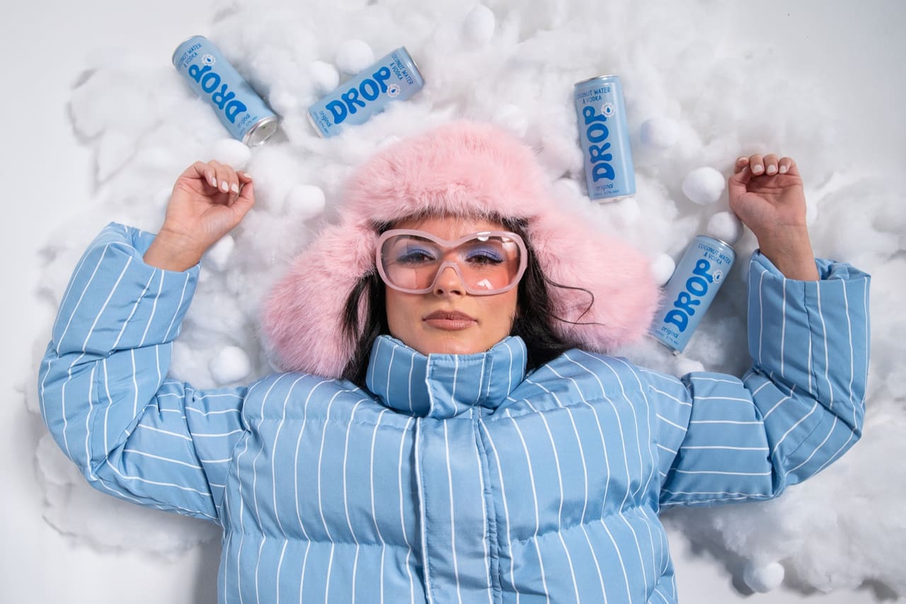 Lying in the snow surrounded by cans